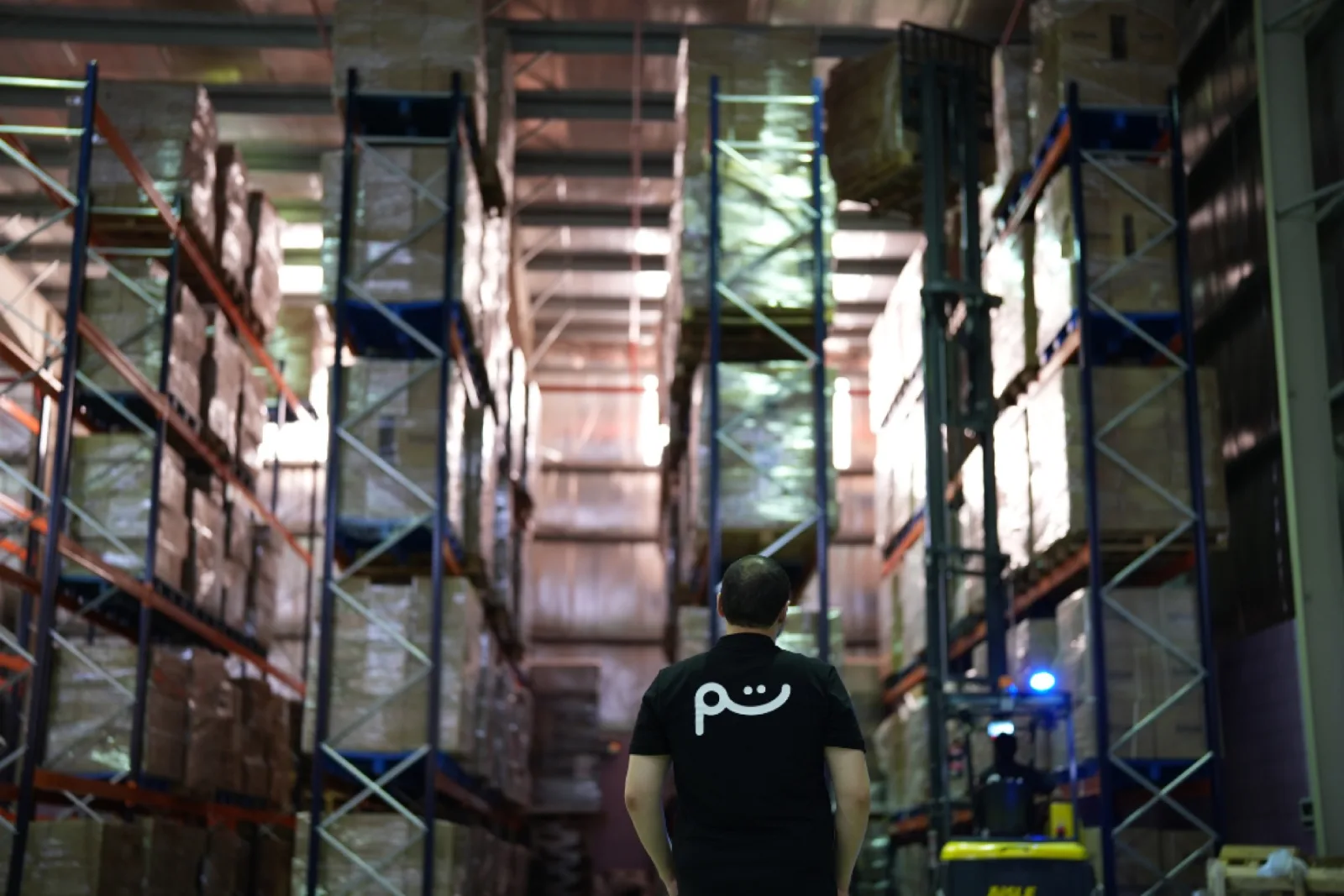 A Tamm operator on a forklift placing a pallet in the racks of our warehouses