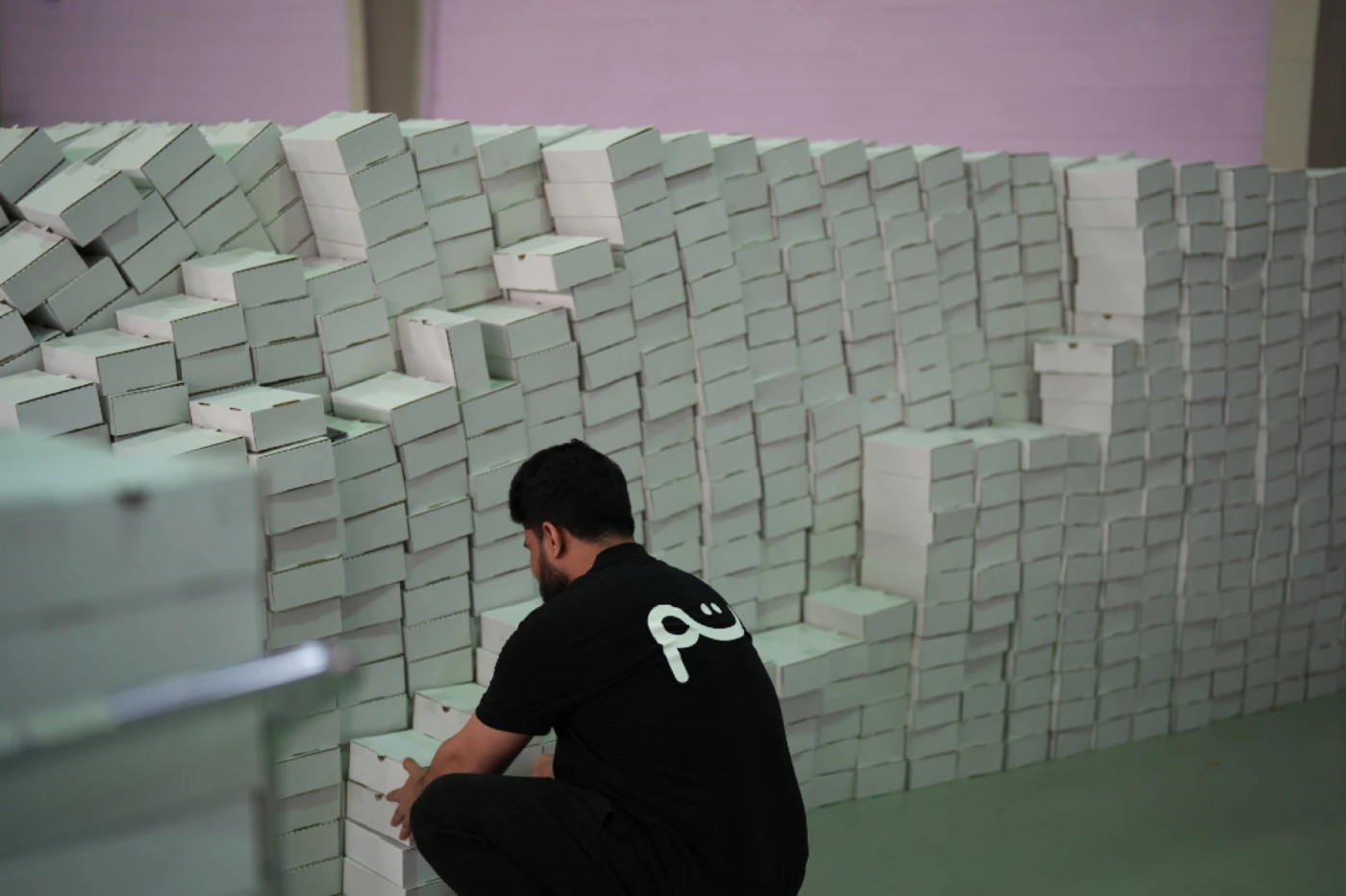A worker building a wall of orders ready to ship