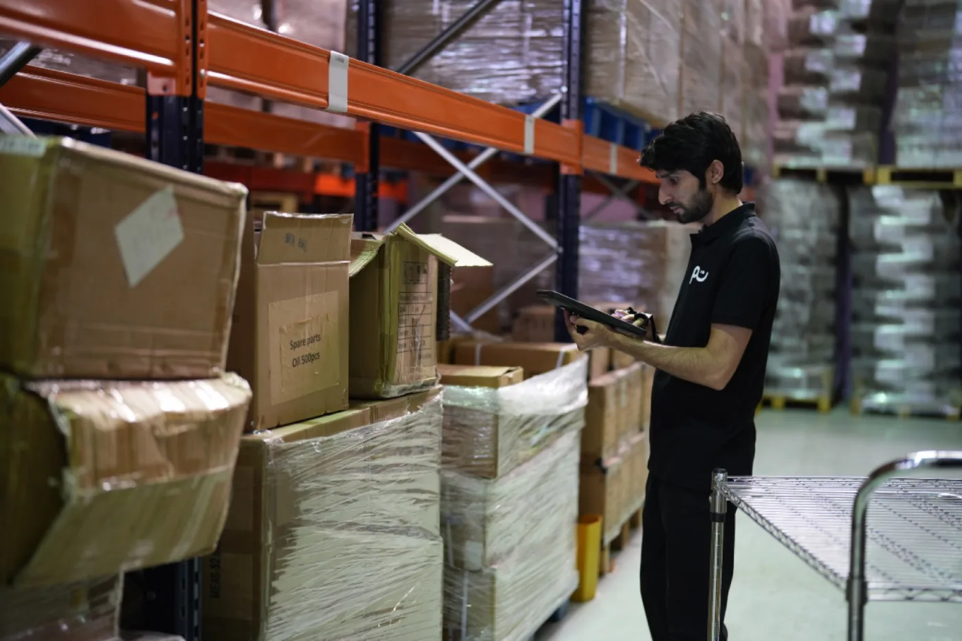 A Tamm worker receiving and logging boxes on pallets in the receiving area